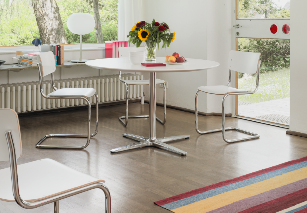 Thonet S43 stoelen in wit met verchroomd frame rond ronde witte tafel met bloemen en fruit in lichte eetkamer &ndash; Van Til Interieur.